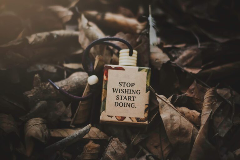 Motivational quote on fallen leaves.